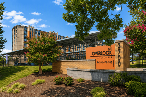 A building with a sign that reads "Overlook" is surrounded by trees and shrubs.
