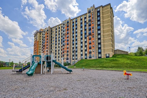 a playground with slides in front of an apartment building