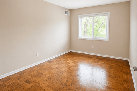 A room with a wooden floor and a window.