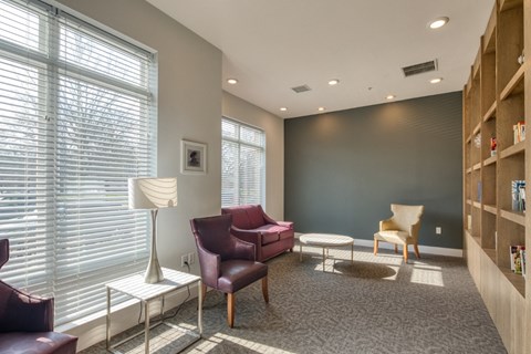 a living room with couches and chairs and a bookshelf