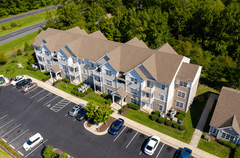 A large apartment complex with a parking lot in front.