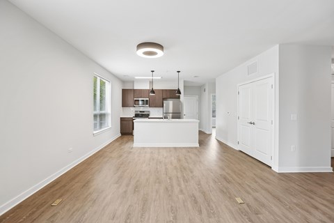 A kitchen with white cabinets and a wooden floor.