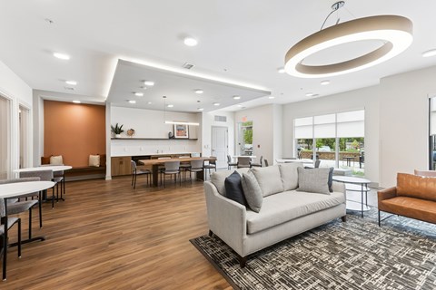 A modern living room with a grey sofa and a wooden floor.