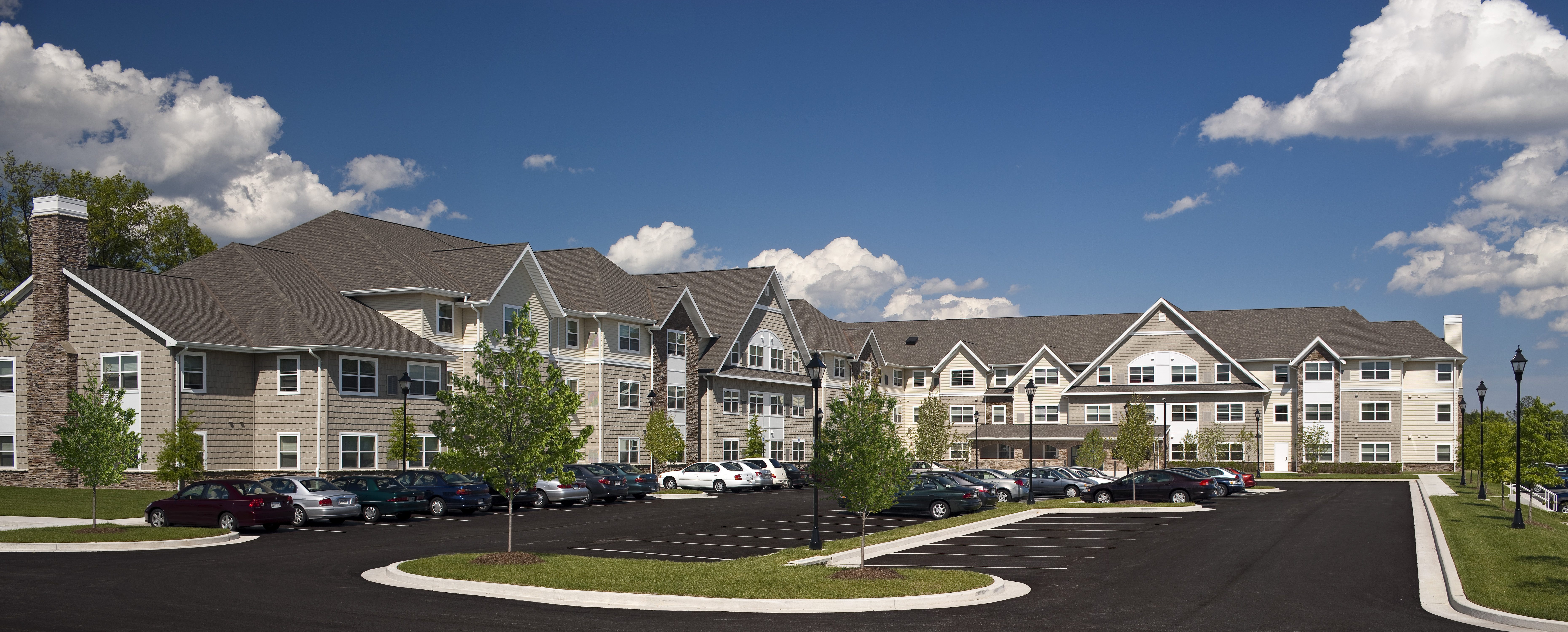 A large building with a parking lot in front.