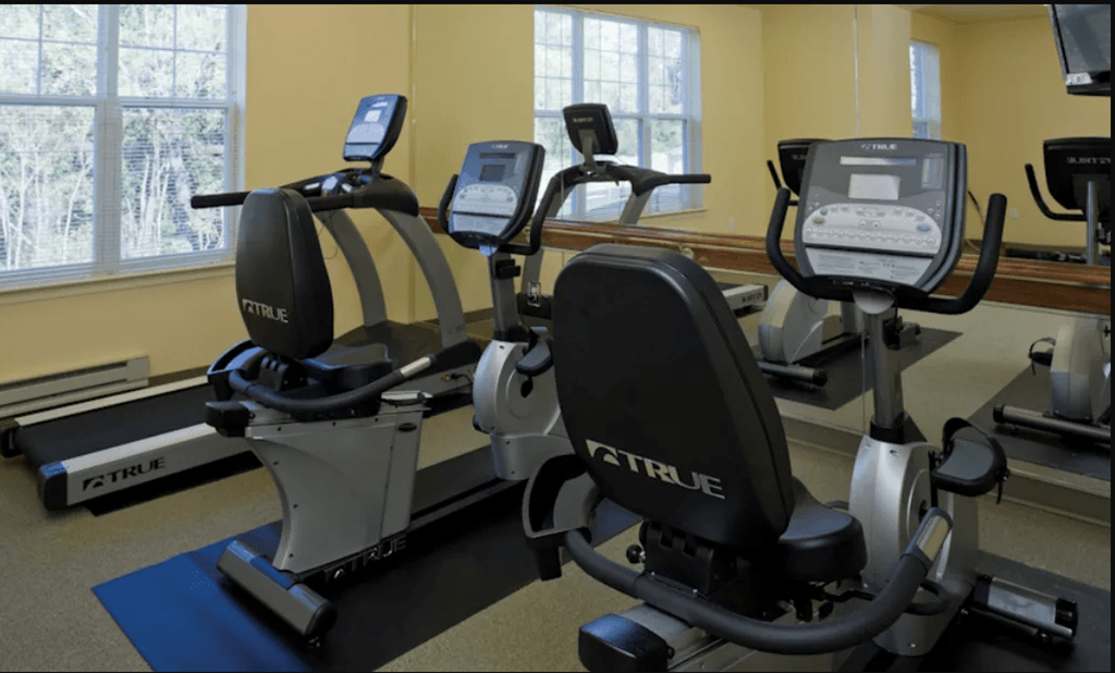 a room with a row of exercise bikes in front of a window