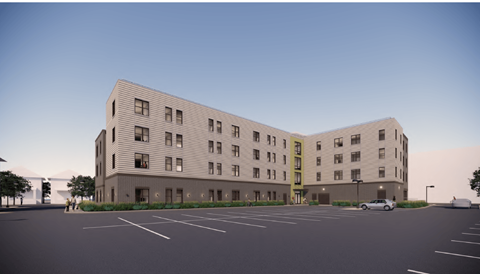 A modern building with a parking lot in front.