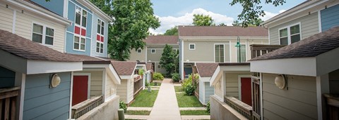 a row of houses with red doors and a sidewalk