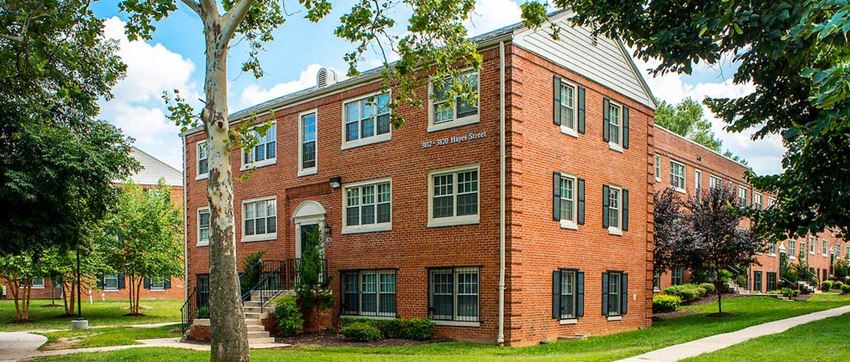 a red brick building with green grass and trees