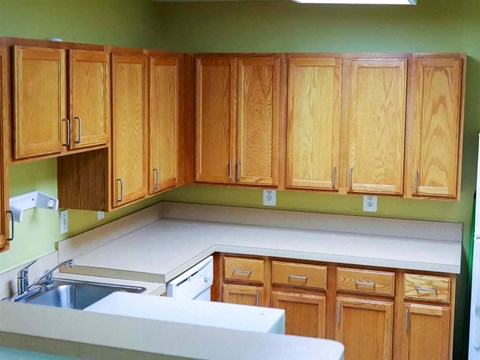 A kitchen with wooden cabinets and a white countertop.