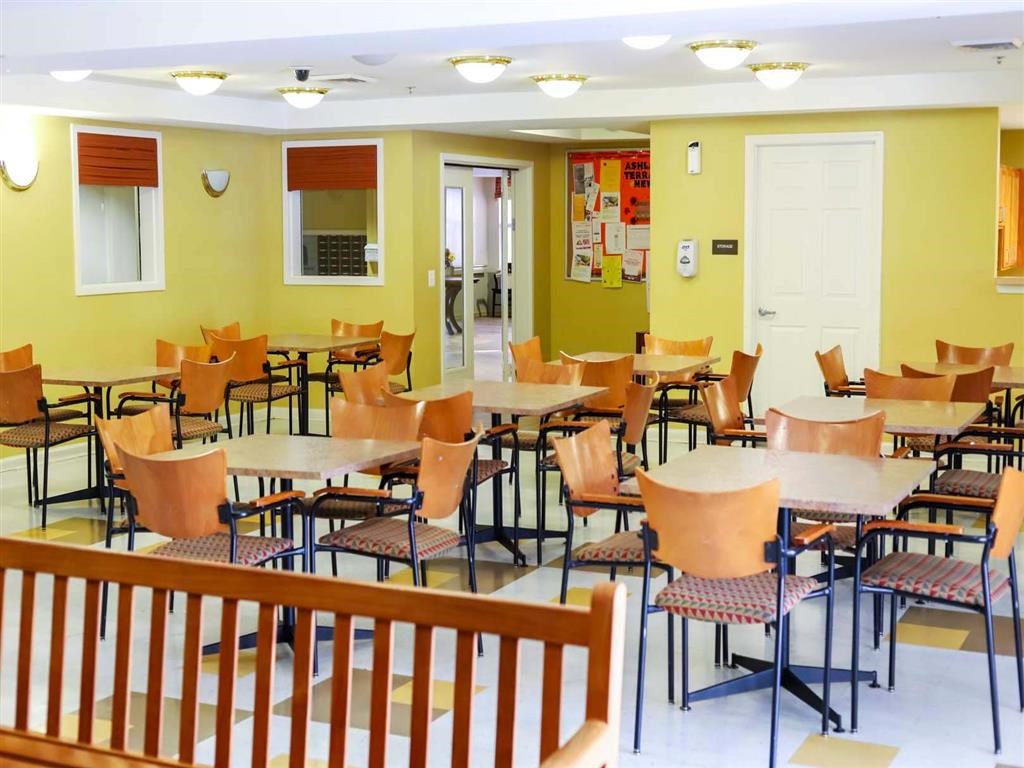 A room with tables and chairs and a white door.
