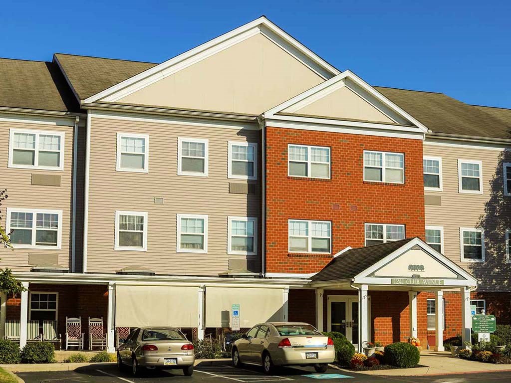 a large brick apartment building with cars parked in front