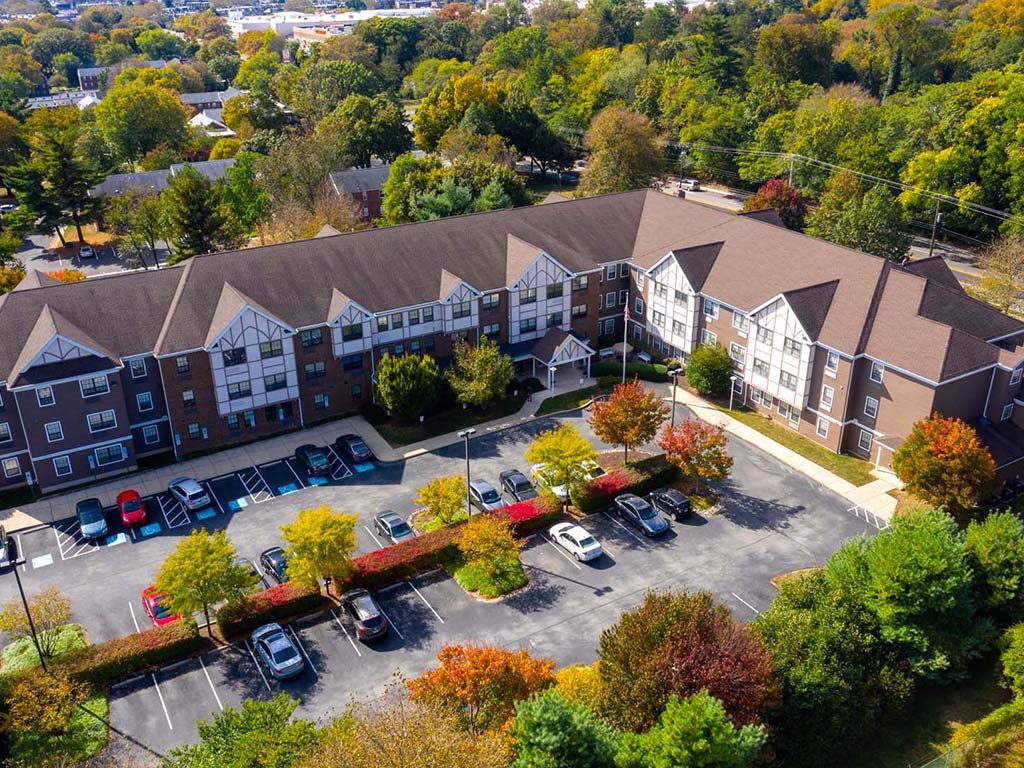 an aerial view of a building with cars parked in a parking lot