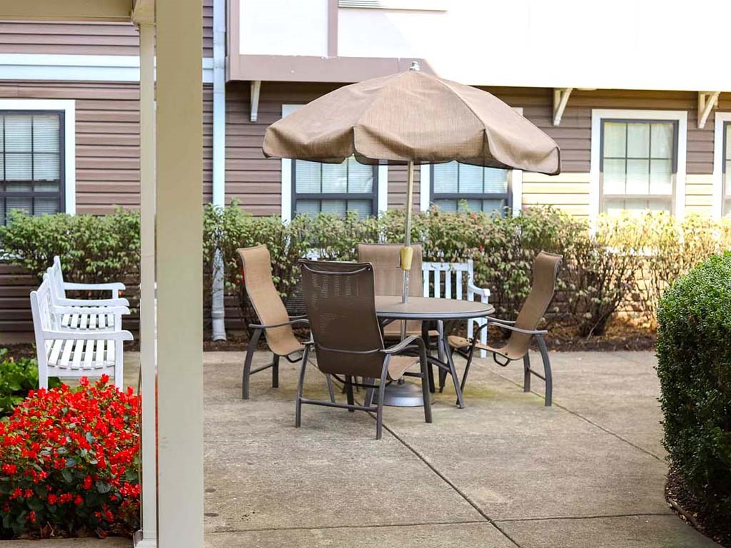 a table with chairs and an umbrella on a patio