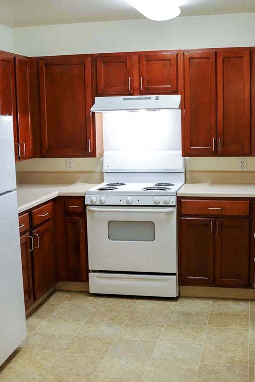a kitchen with a white stove and a refrigerator