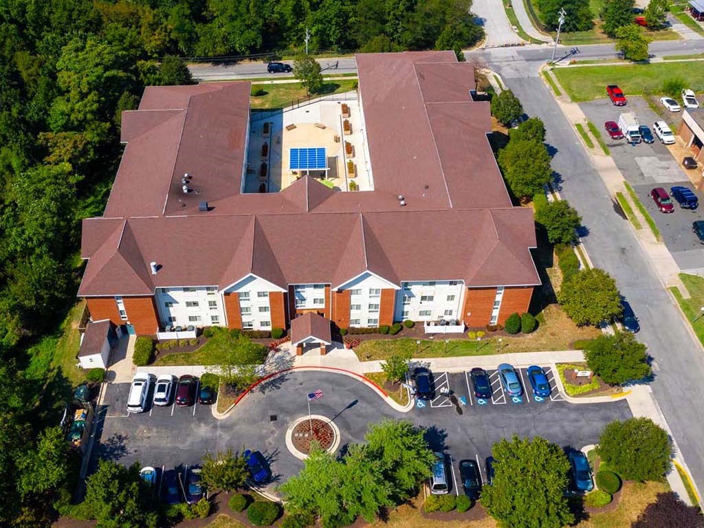 an aerial view of a large building with cars parked in front
