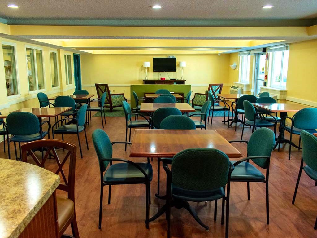 a conference room with tables and chairs and a television
