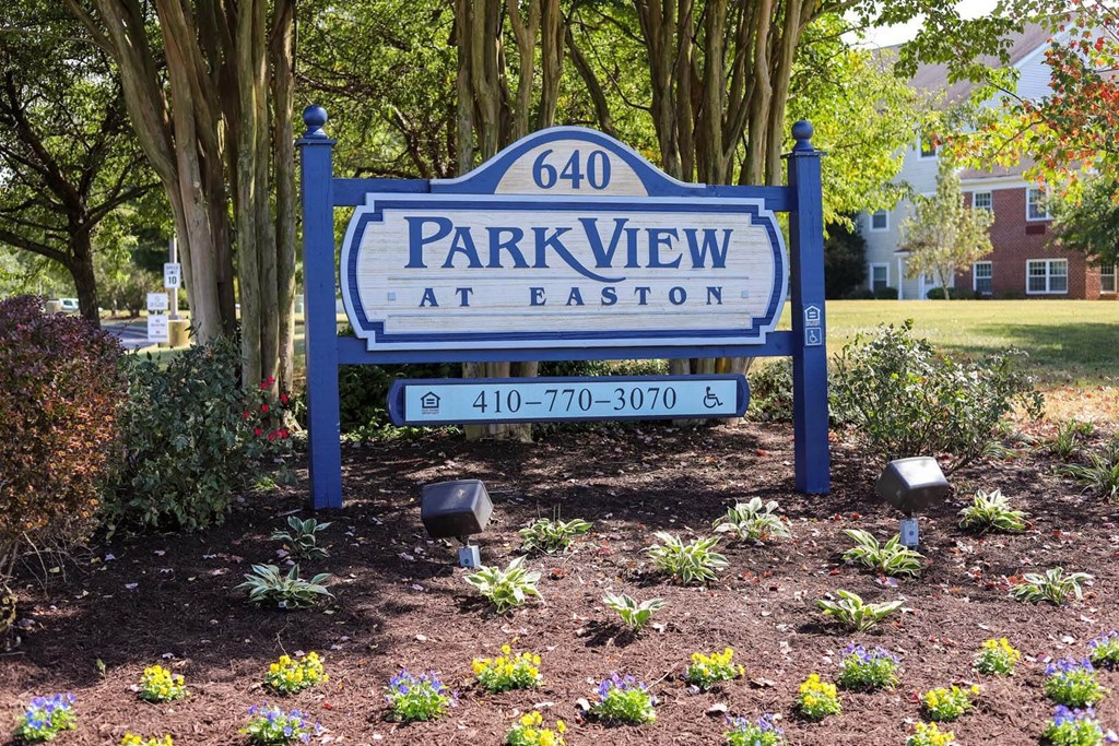 a blue park view sign in front of a garden