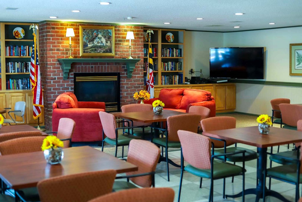 a living room with tables and chairs and a fireplace