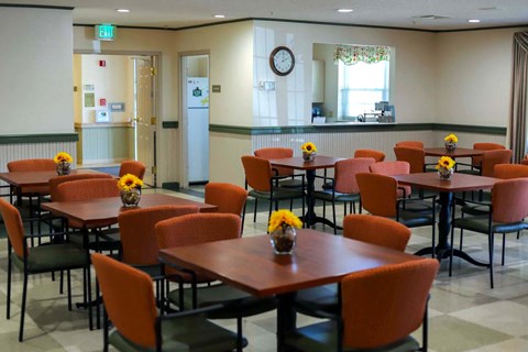 a dining room with tables and chairs and a clock on the wall