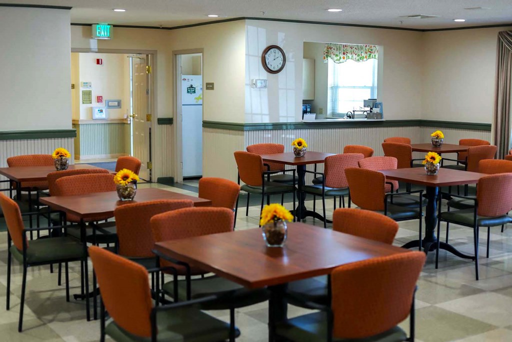 a dining room with tables and chairs and a clock on the wall