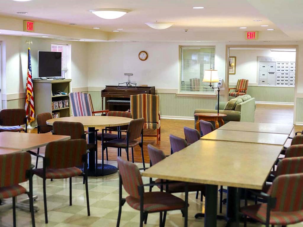 a dining room with tables and chairs and a piano