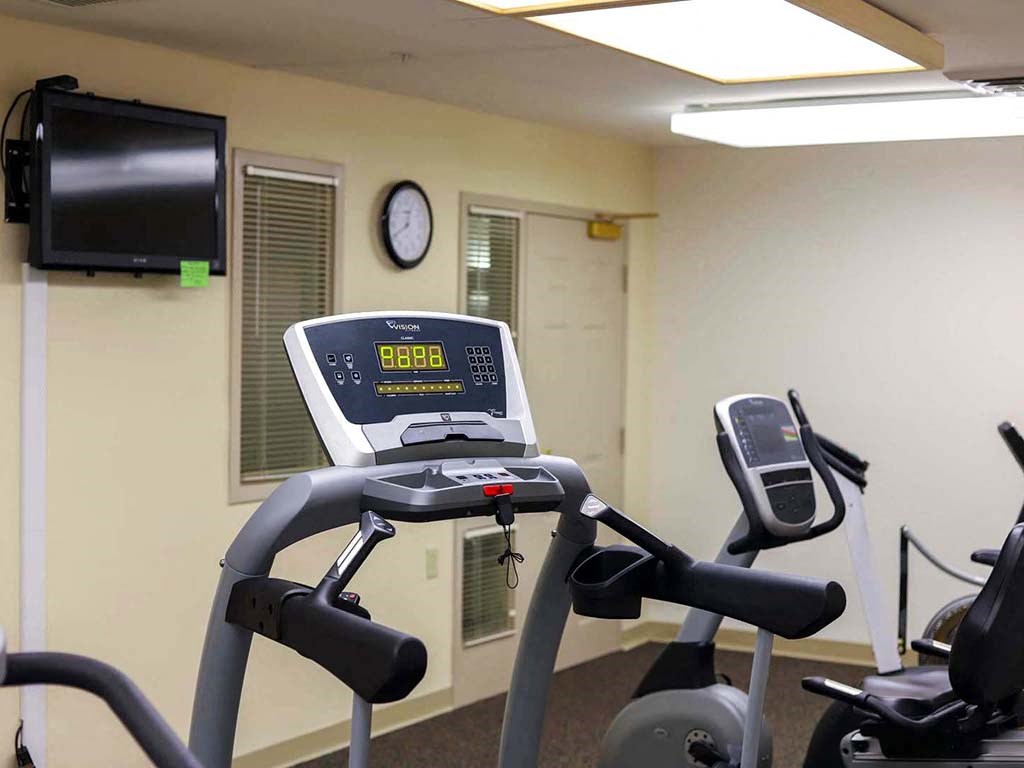 a workout room with a treadmill and a tv