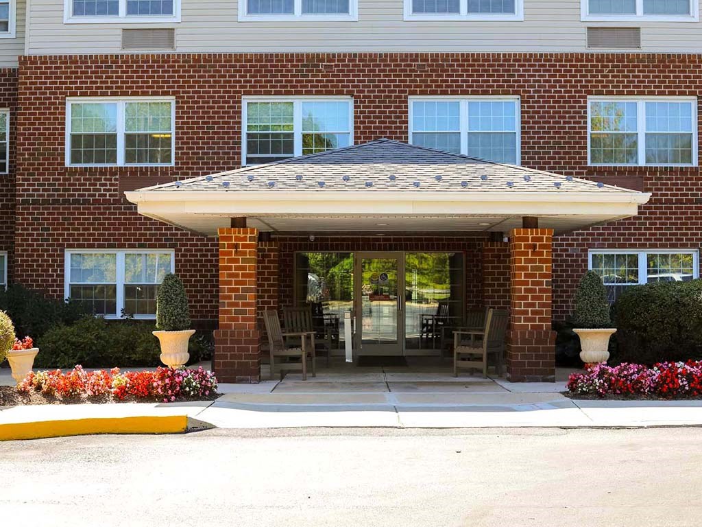 the front entrance of a brick building with a patio umbrella