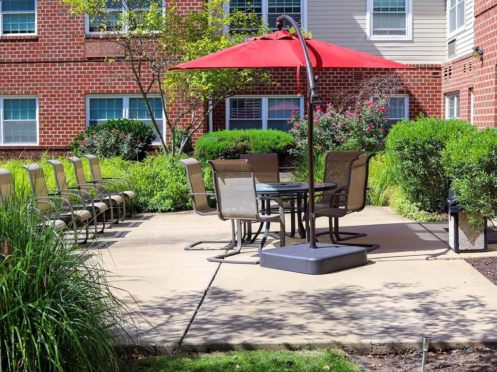 a patio table with a red umbrella and chairs