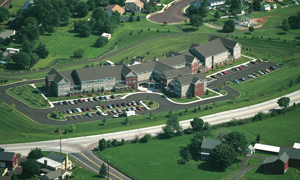 an aerial view of a building with cars parked in a parking lot