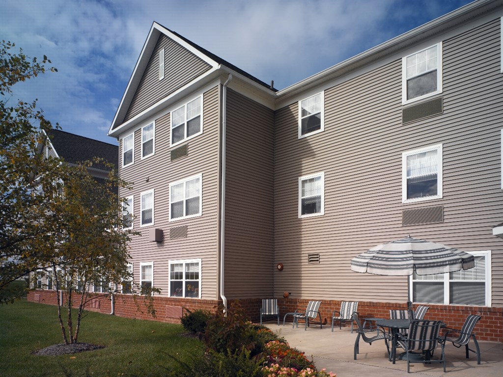 a patio with an umbrella in front of a building