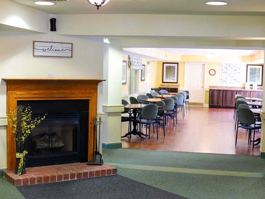 a living room with a fireplace and a table with chairs