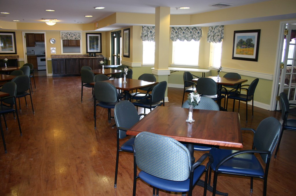 a dining room with tables and chairs and a kitchen