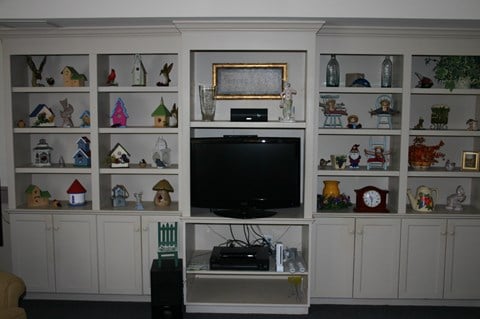a living room with a television and shelves