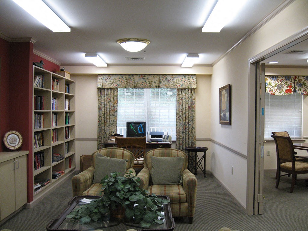 a waiting room with chairs and a table with a laptop