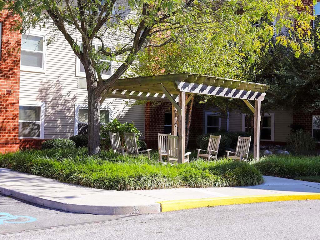 a group of chairs sitting under a wooden canopy