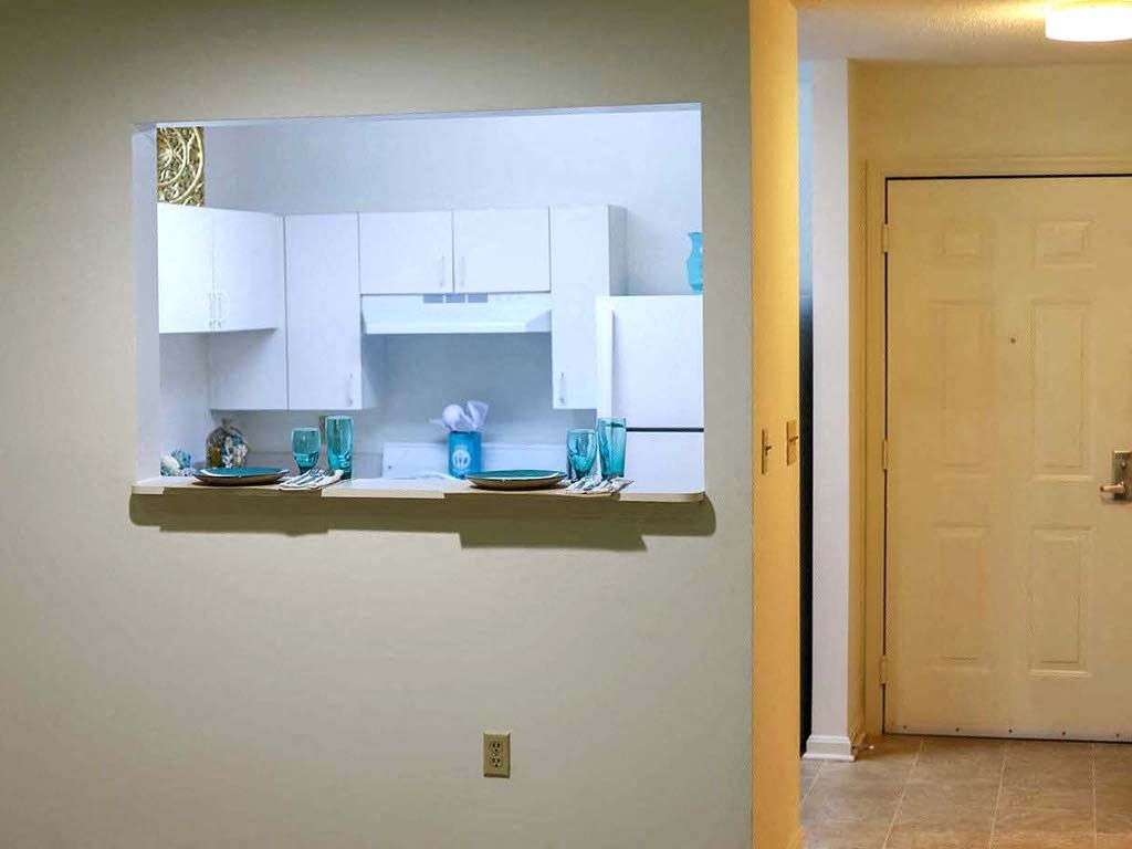 a kitchen with white cabinets and a counter with blue glasses