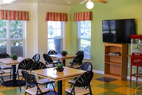 a dining room with tables and chairs and a tv