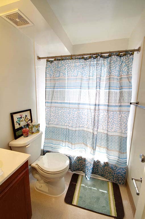 a bathroom with a toilet and a shower curtain