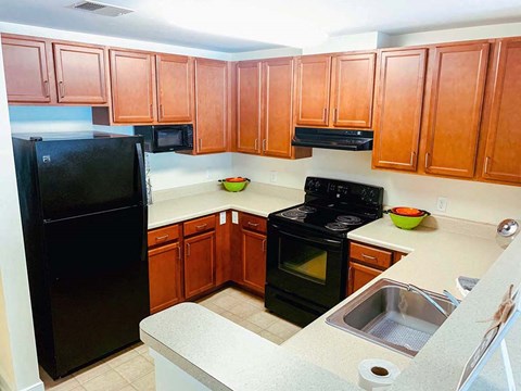 a kitchen with black appliances and wooden cabinets