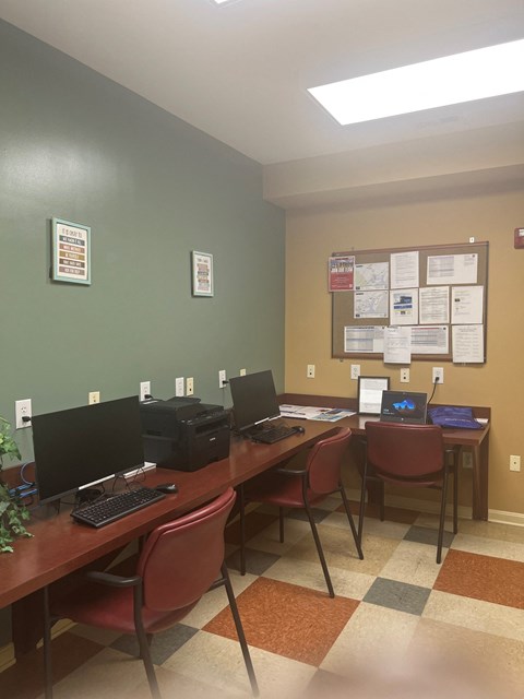 a computer room with three desks with computers and chairs