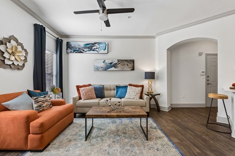 A living room with a sofa, a coffee table, and a painting on the wall.