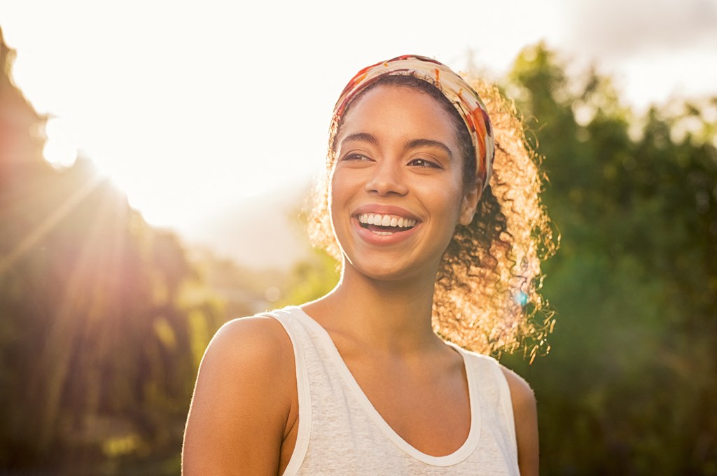 a woman smiling with the sun shining on her face