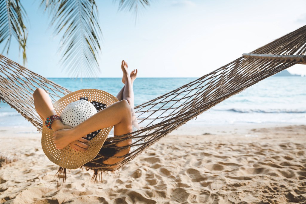 woman sleeping in a hammock on the beach