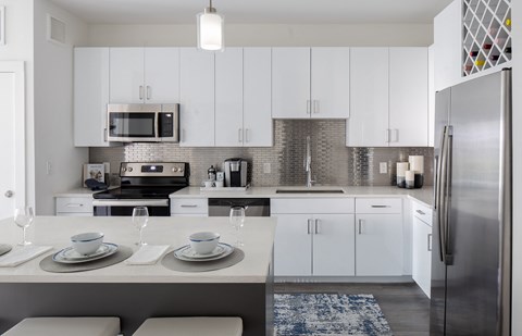 A modern kitchen with white cabinets and a large island.