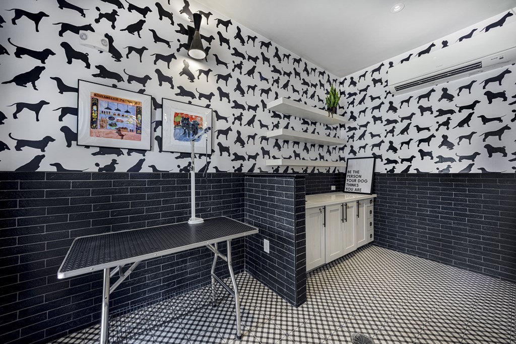 A room with a black and white checkered floor and a wall covered in black dog silhouettes at Folksong Apartments, Flowery Branch
