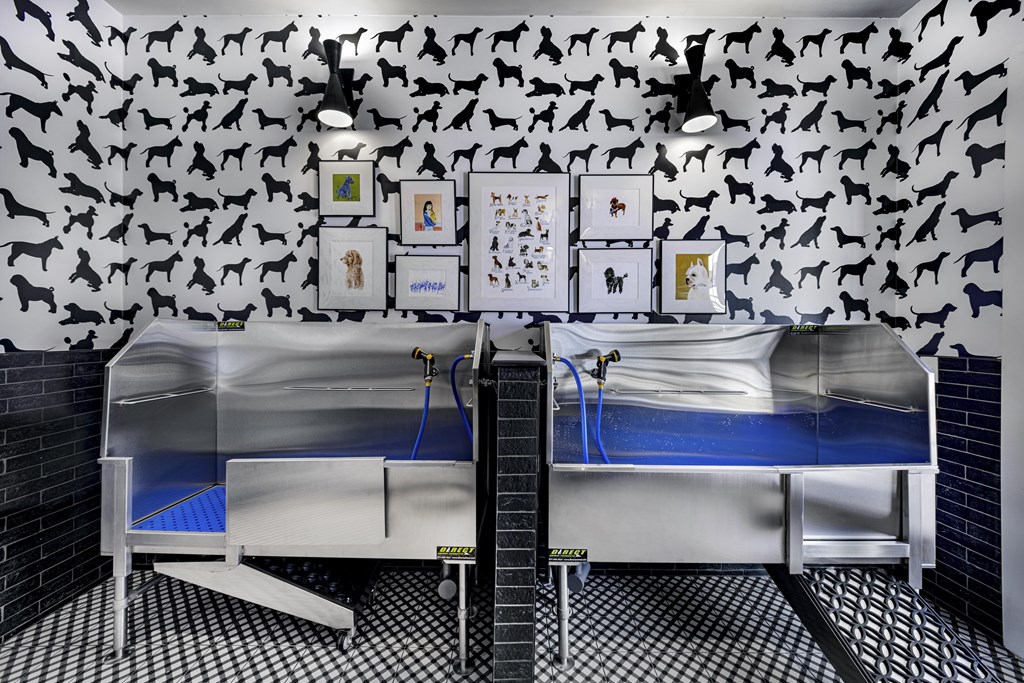 A room with a black and white checkered floor and a wall covered in black dog silhouettes at Folksong Apartments, Georgia