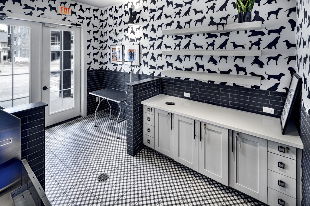 A bathroom with black and white tiles and a wall covered in dog silhouettes at Folksong Apartments, Flowery Branch, GA 30542