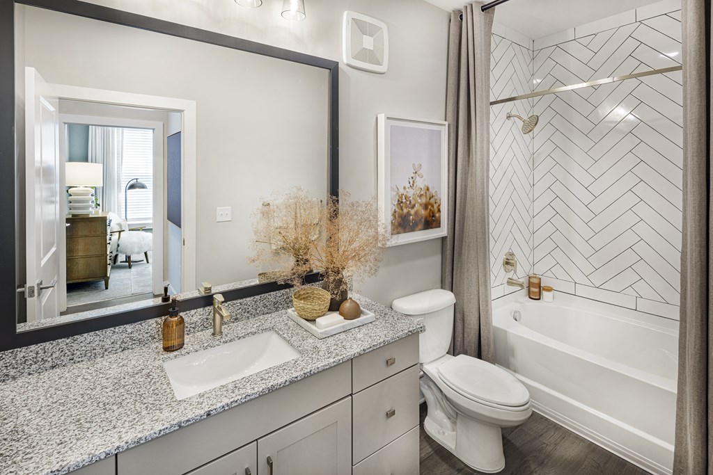 A bathroom with a white toilet, a sink, and a bathtub at Folksong Apartments, Georgia