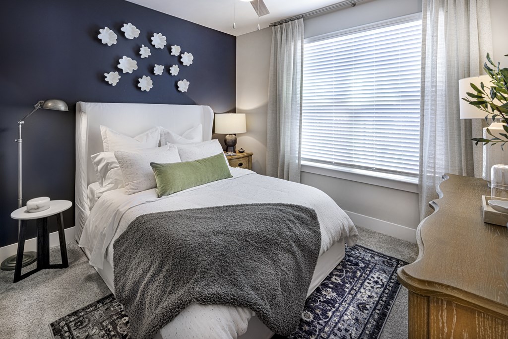 A bedroom with a white bed and a grey blanket at Folksong Apartments, Georgia 30542