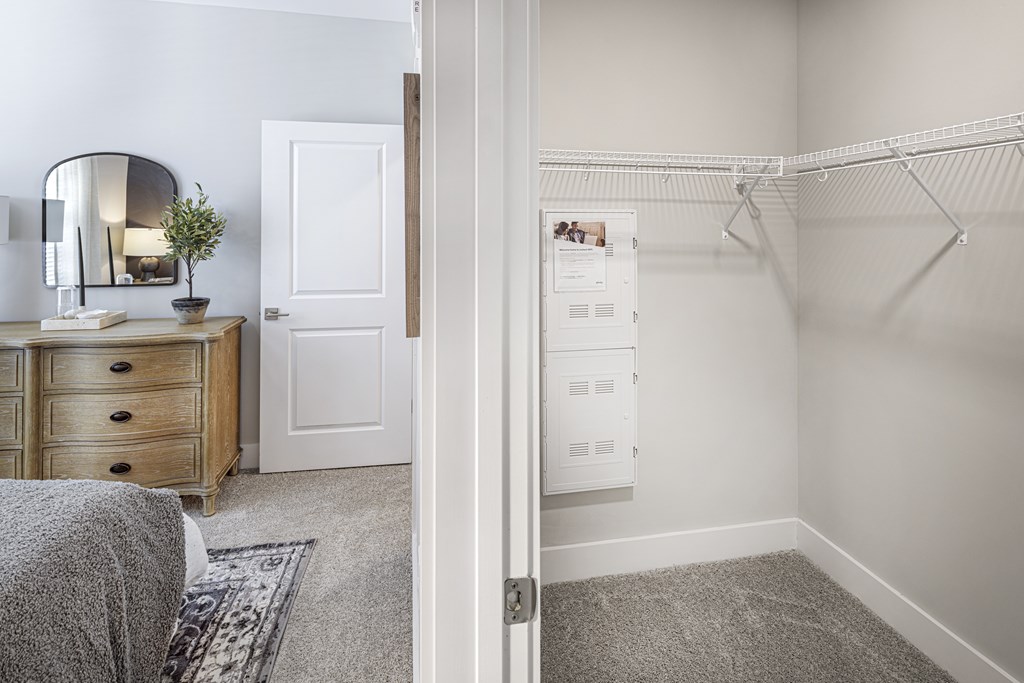 A white bedroom with a grey carpet and a white wardrobe at Folksong Apartments, Flowery Branch, GA